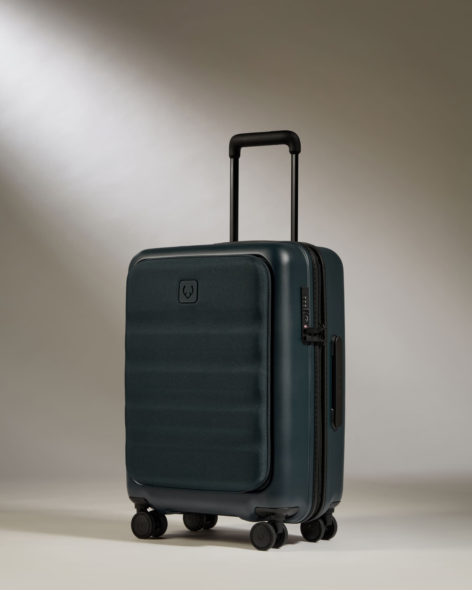 Dark green suitcase with a handle and wheels on a neutral background