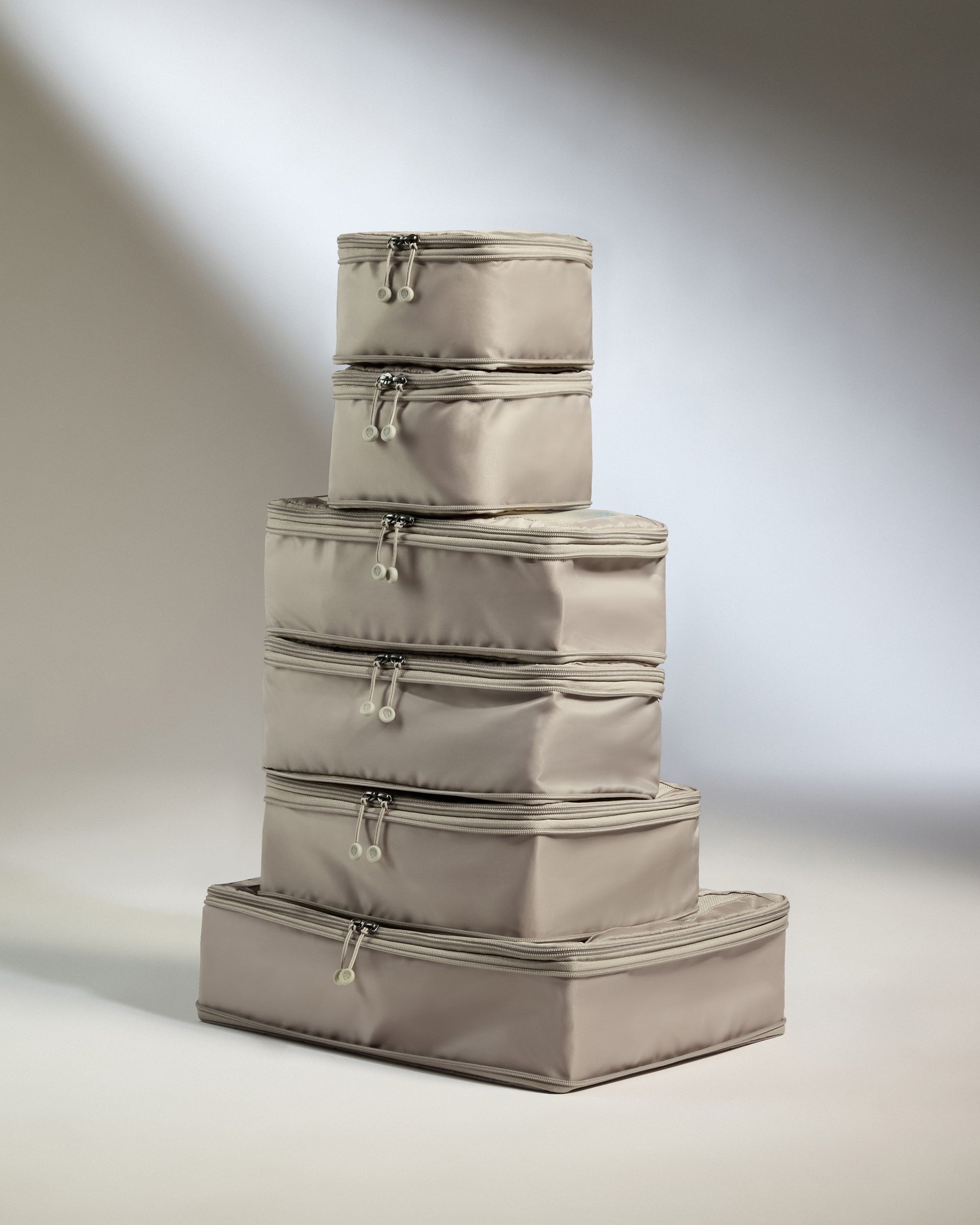 Set of beige storage cubes stacked on a neutral background