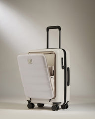 White suitcase with a black handle and wheels on a beige background