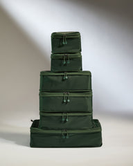 Stack of green packing cubes on a neutral background