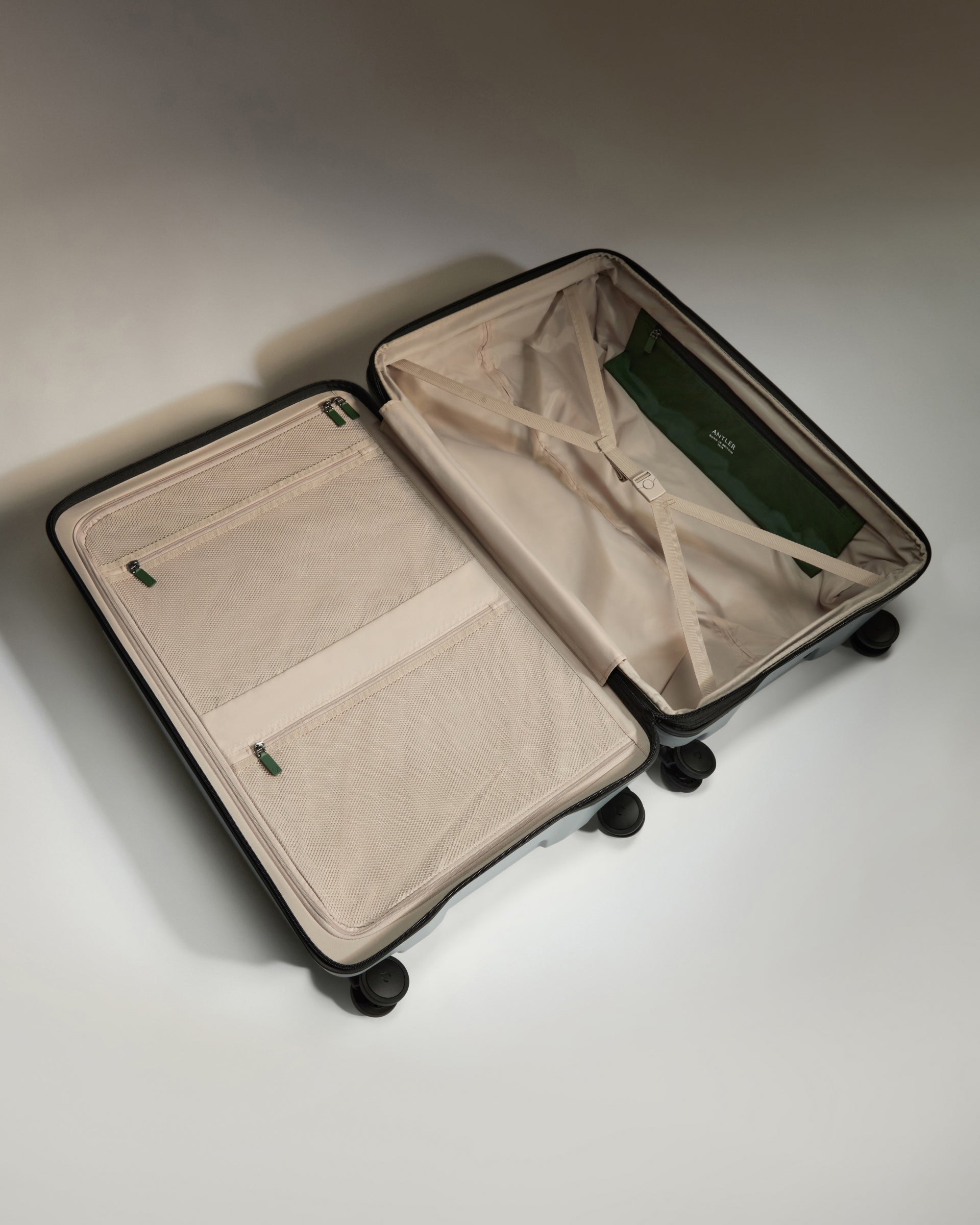 Open beige suitcase on a light gray background