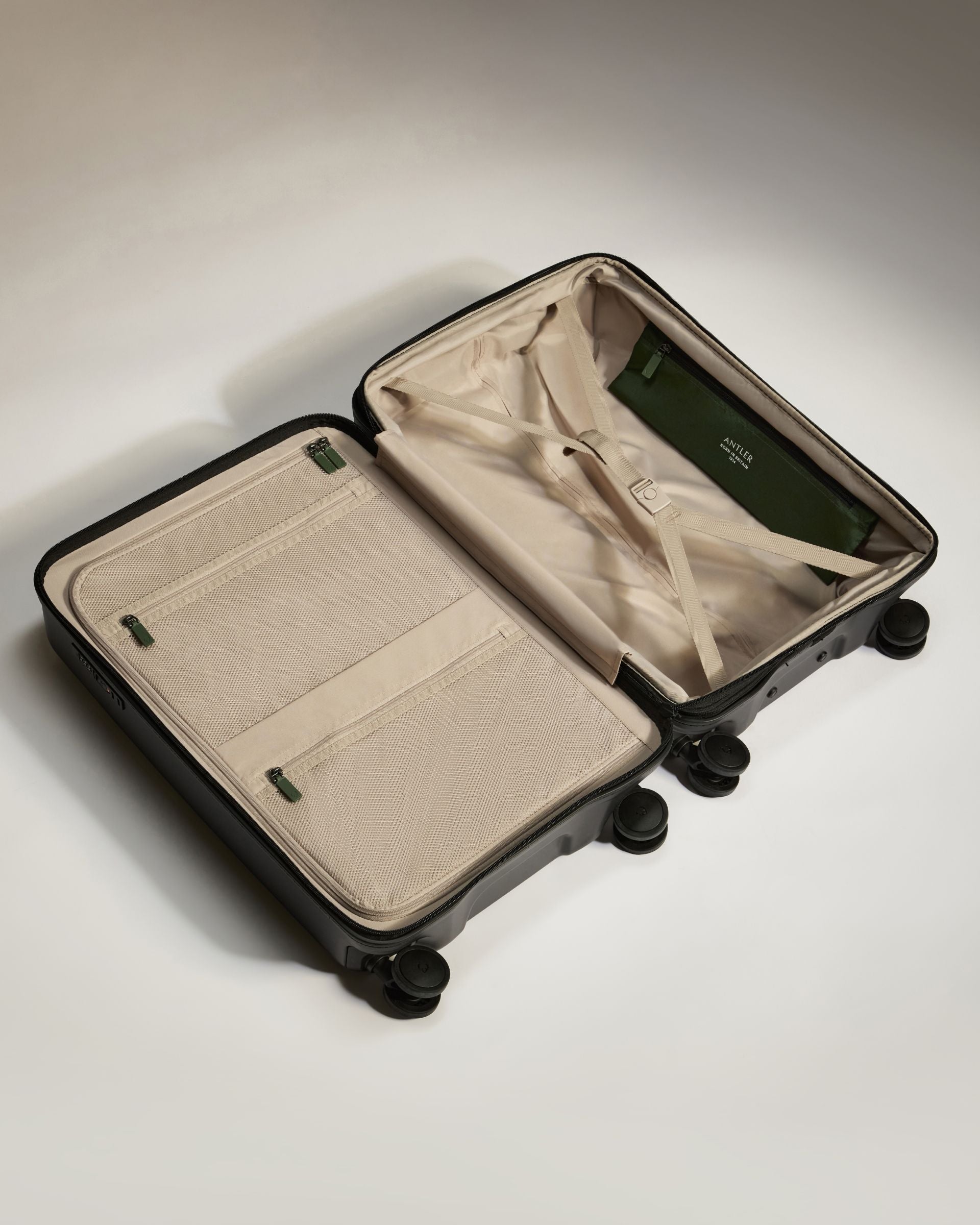 Open suitcase with beige interior on a light gray background