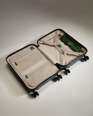 Open suitcase with green interior on a light gray background