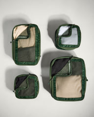 Set of green travel packing cubes on a light gray background