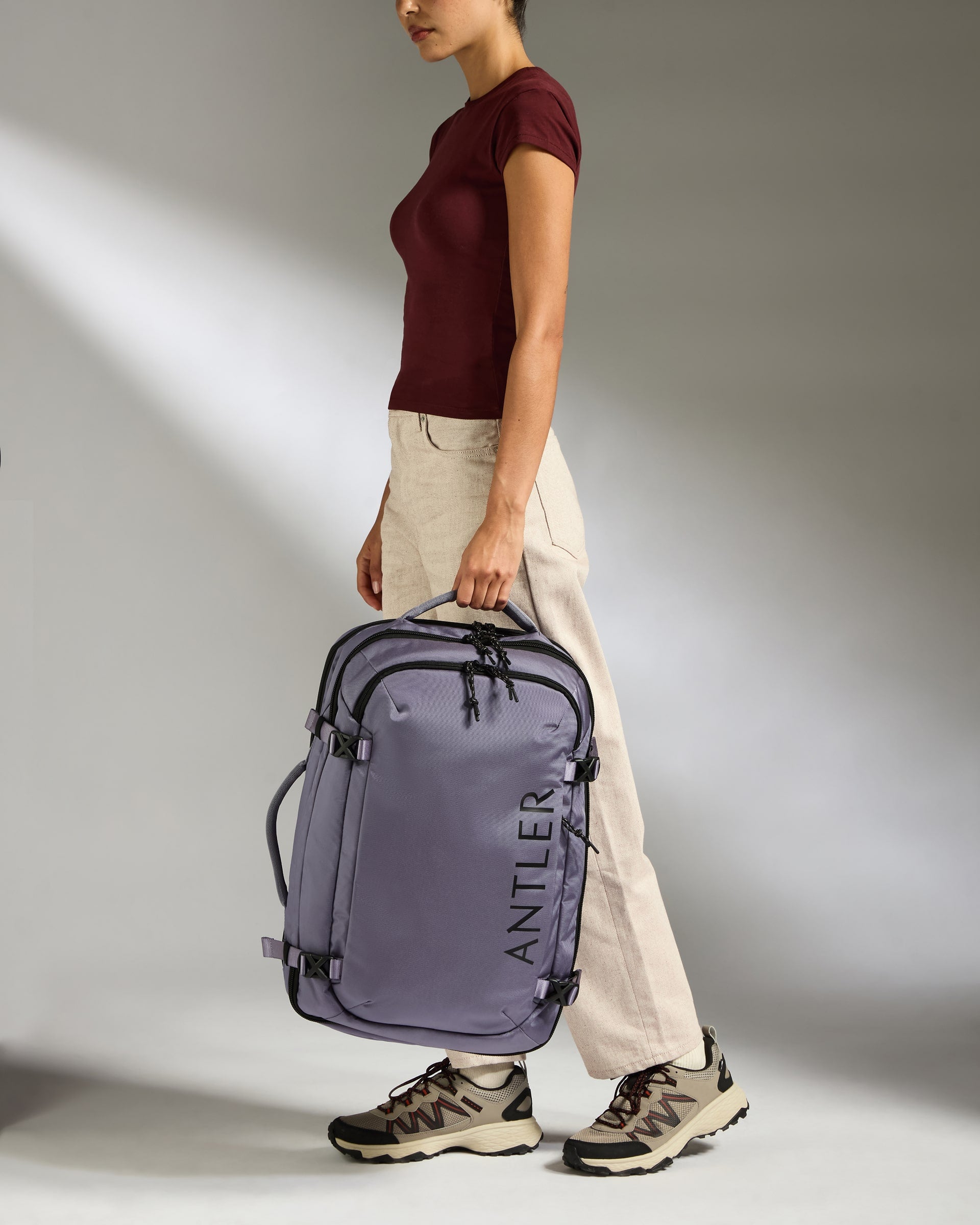 Person holding a purple Antlerk bag against a neutral background