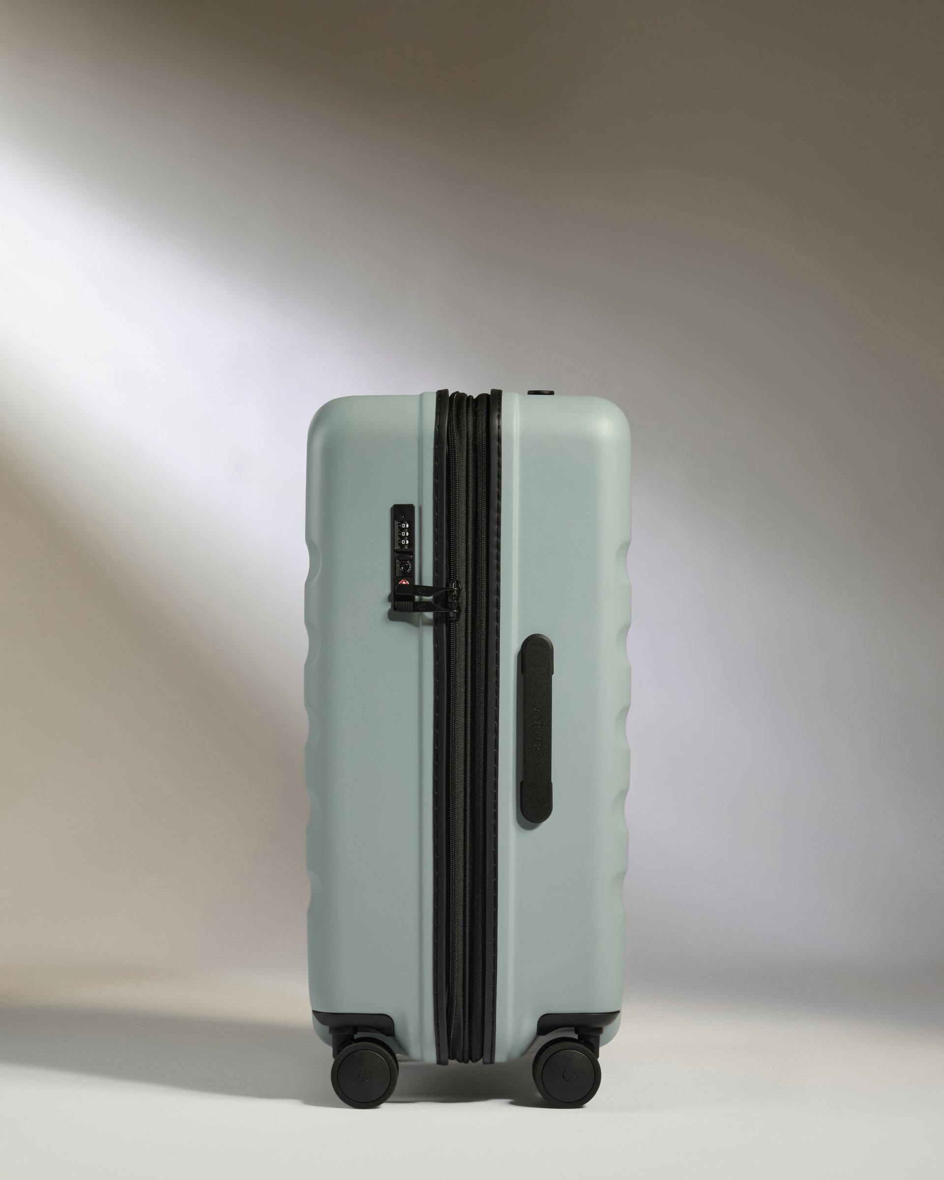 Light blue suitcase with black handle and wheels on a white background