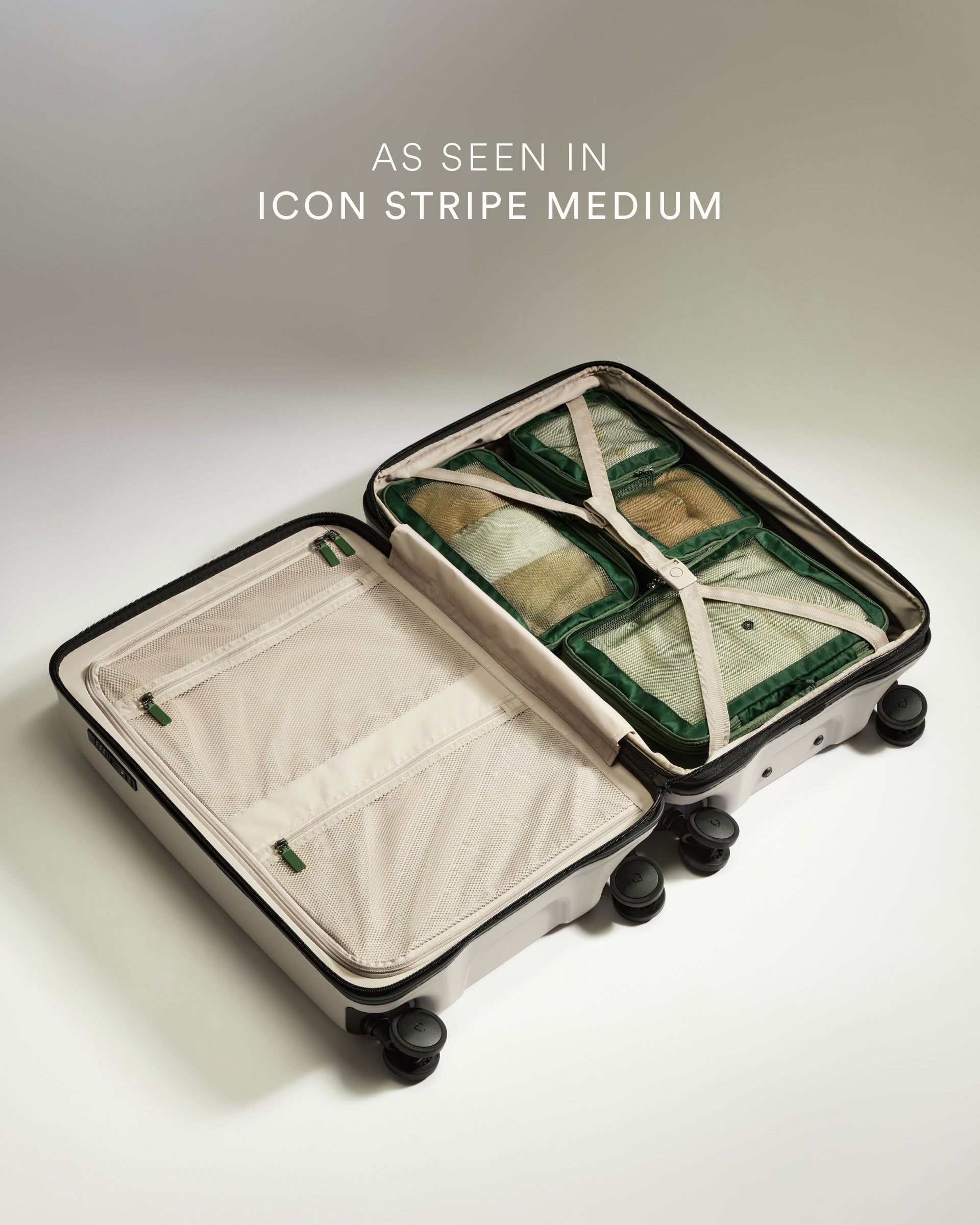 Open suitcase with green packing cubes on a light background