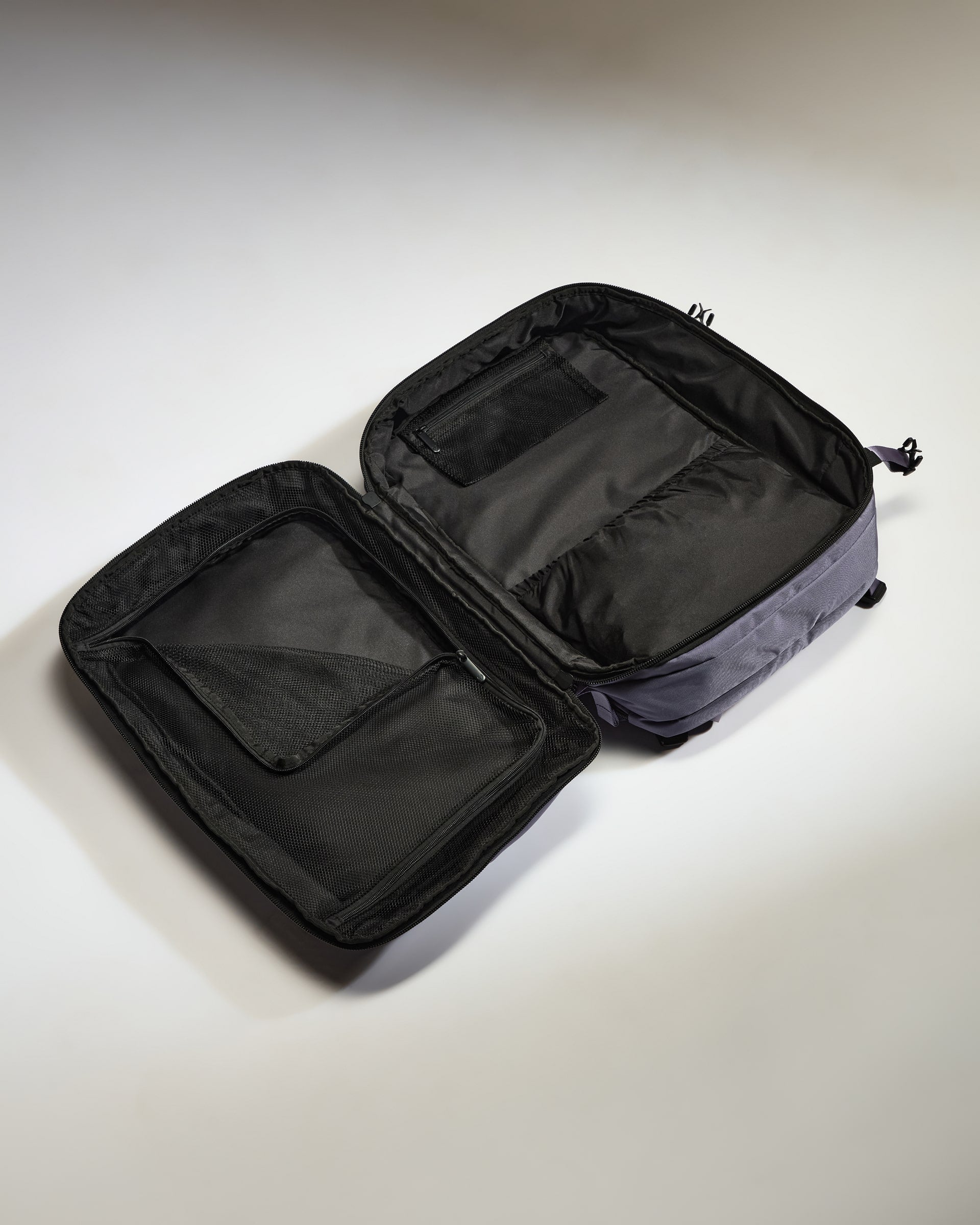 Open black travel bag on a light gray background