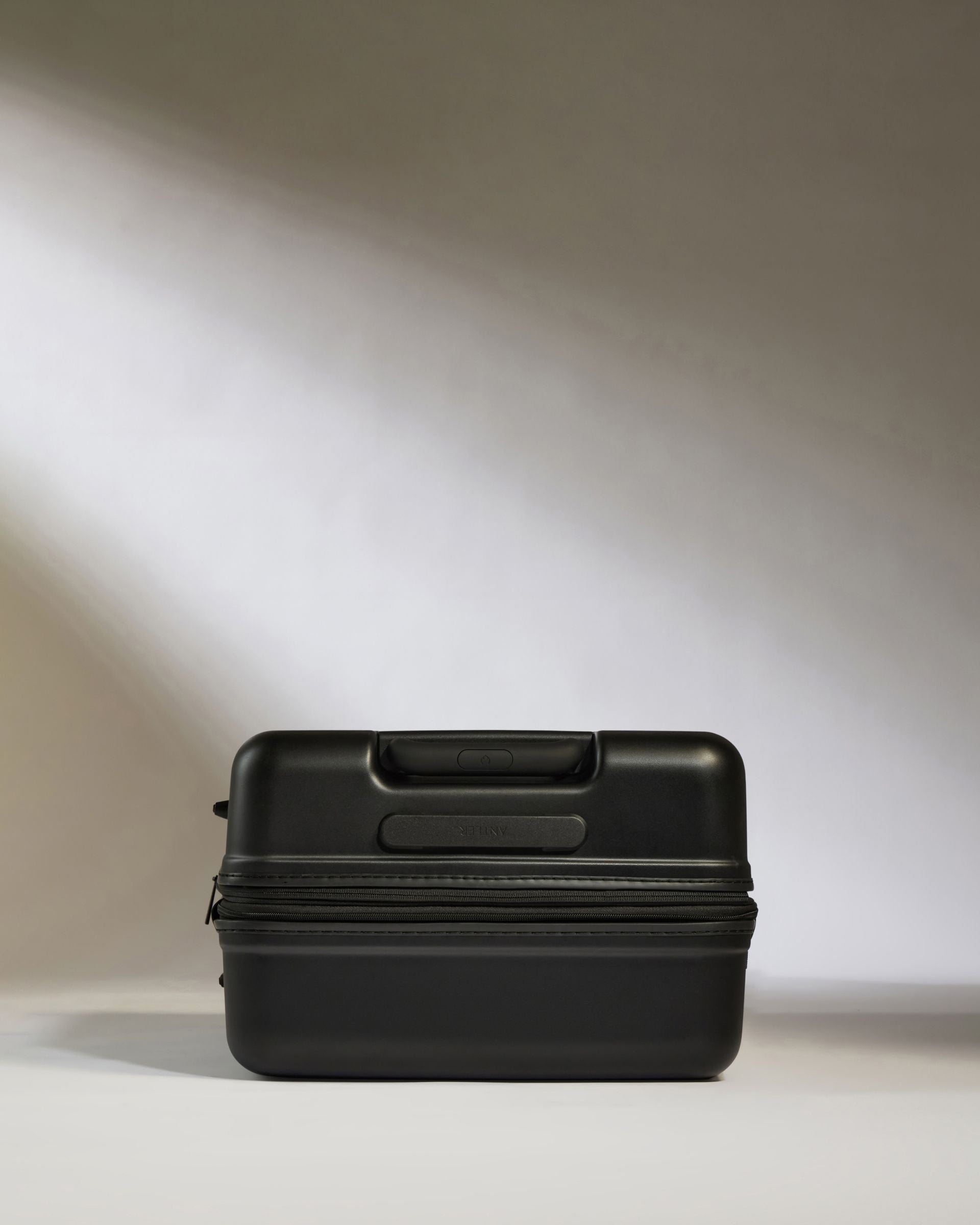Black suitcase on a light gray background
