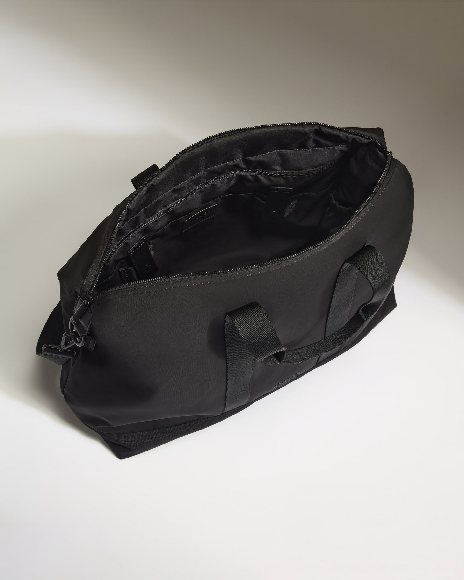 Black duffel bag on a light gray background