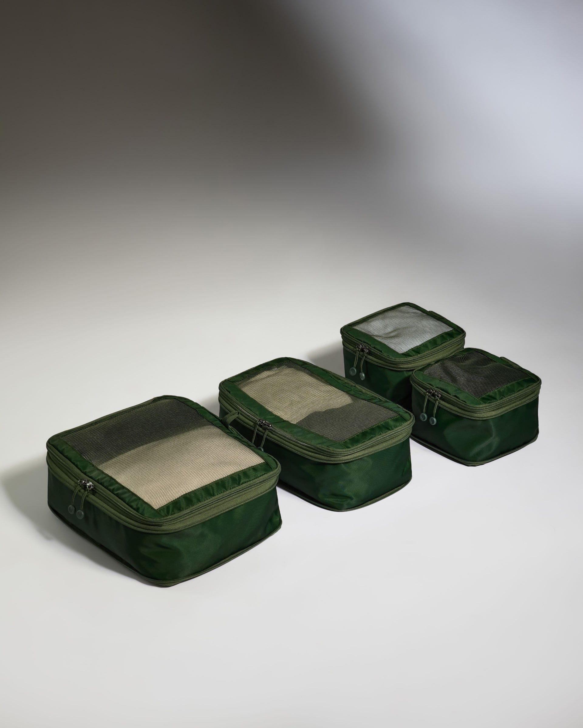 Set of green packing cubes on a gray background