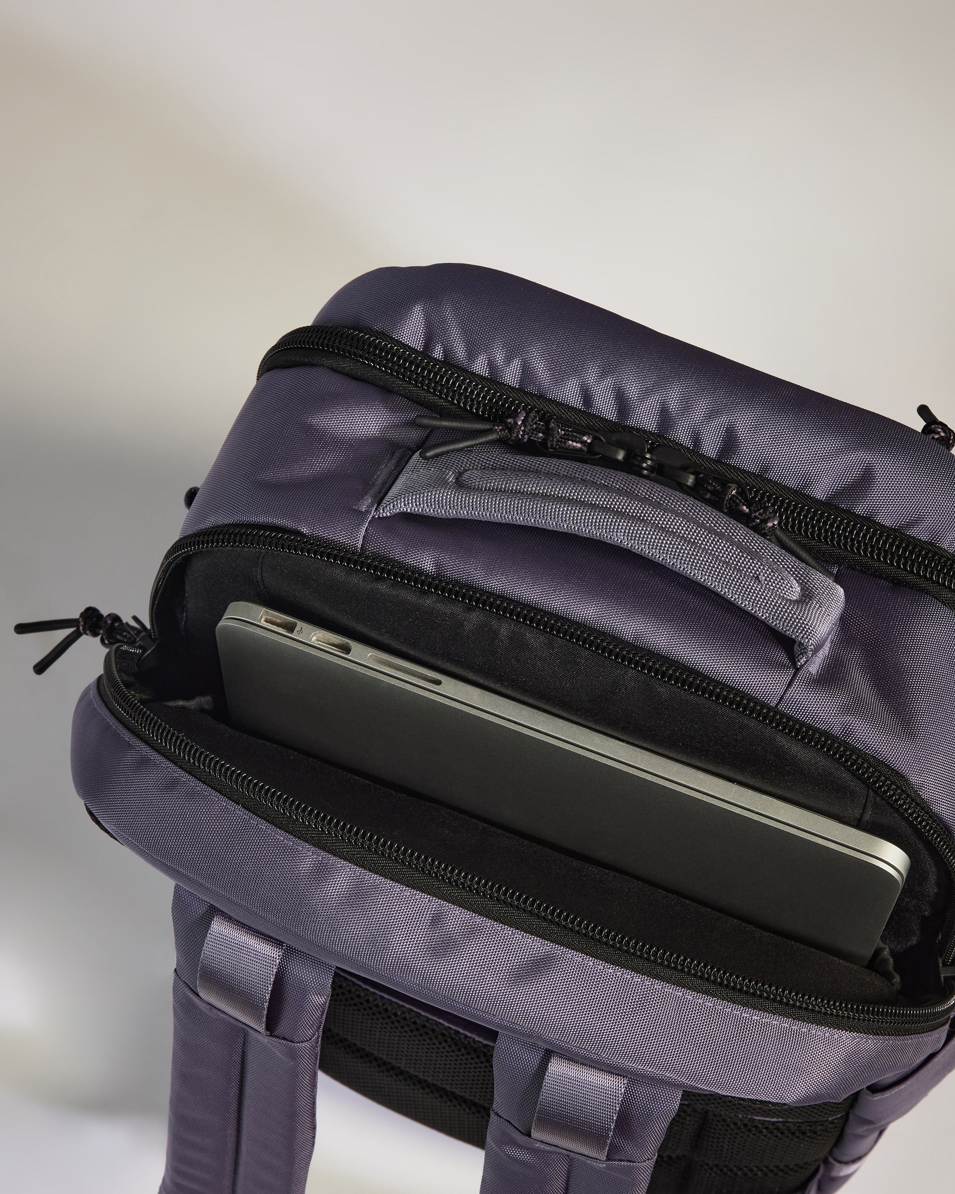 Purple backpack with a laptop compartment on a light gray background