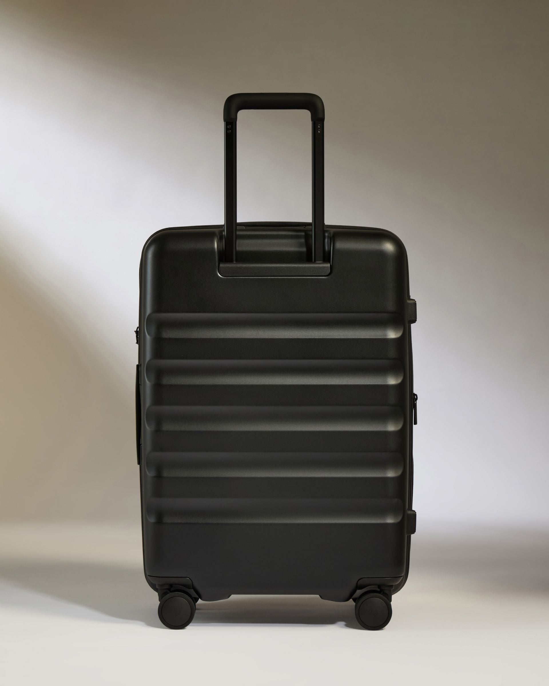 Black suitcase on a light gray background