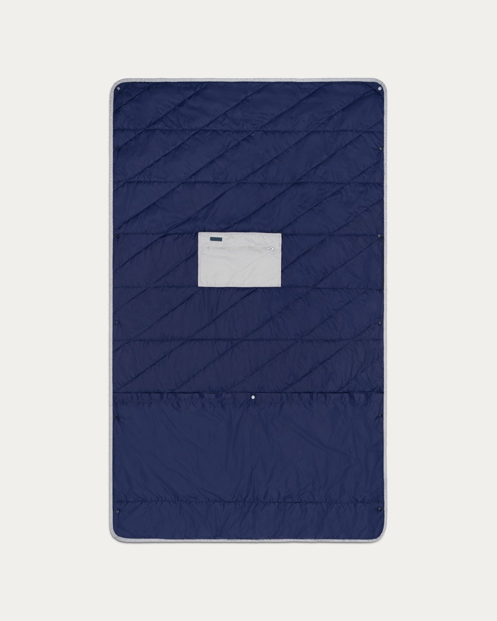 Navy quilted cover with a brand label on a light gray background