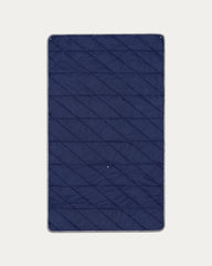 Blue quilted mat on a light gray background