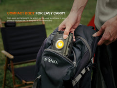 Person placing a flashlight into a backpack with text about its compact design.