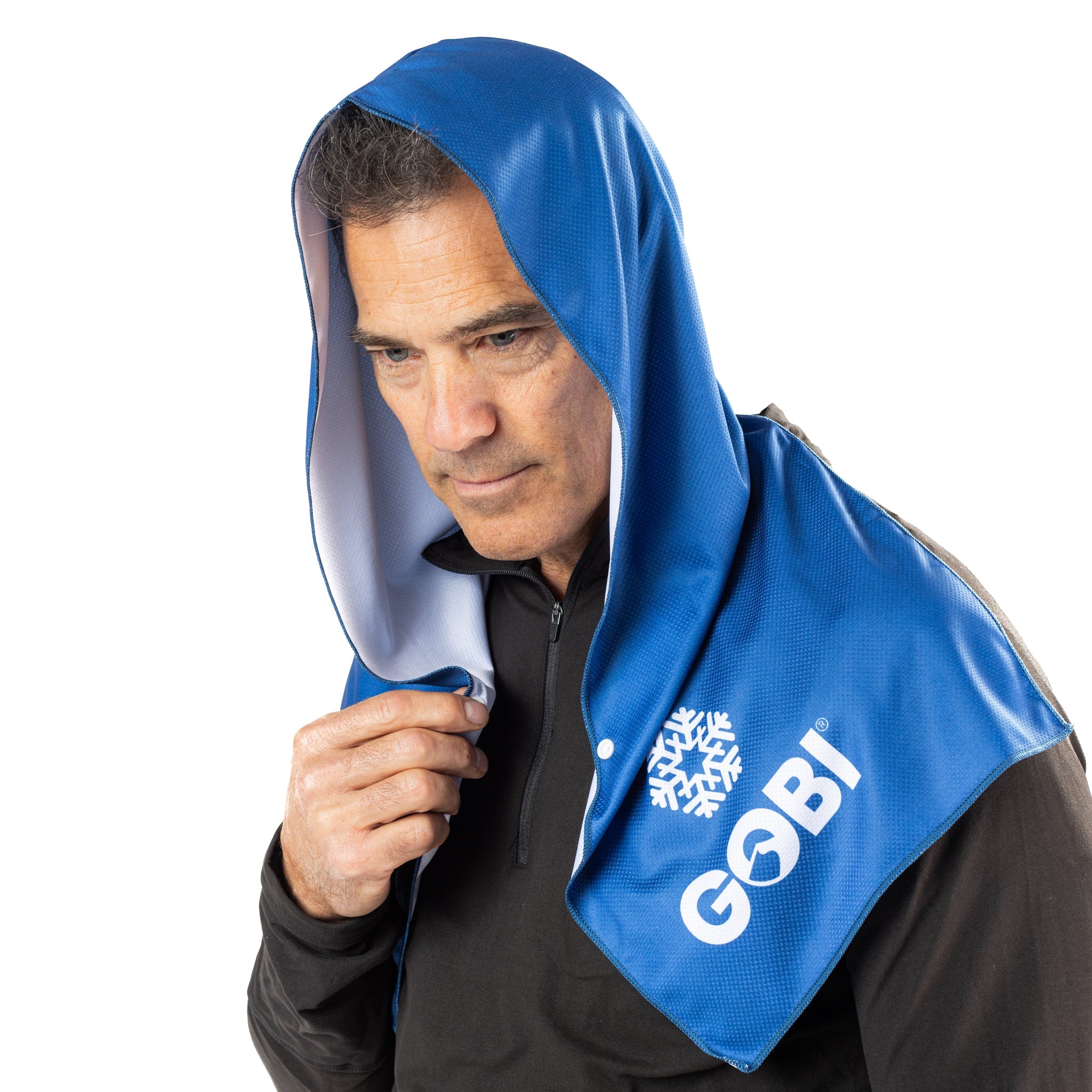 Man wearing a blue towel with 'Gobi' branding over his head on a white background