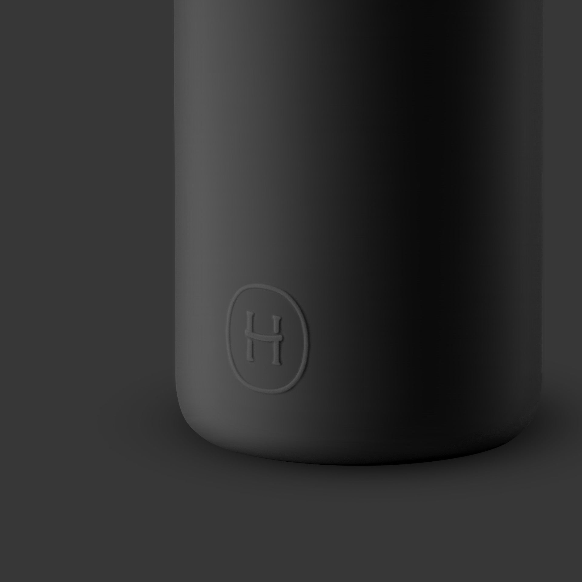 Black cylindrical object with a logo on a dark background