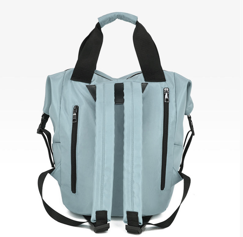 Light blue backpack with black straps on a white background