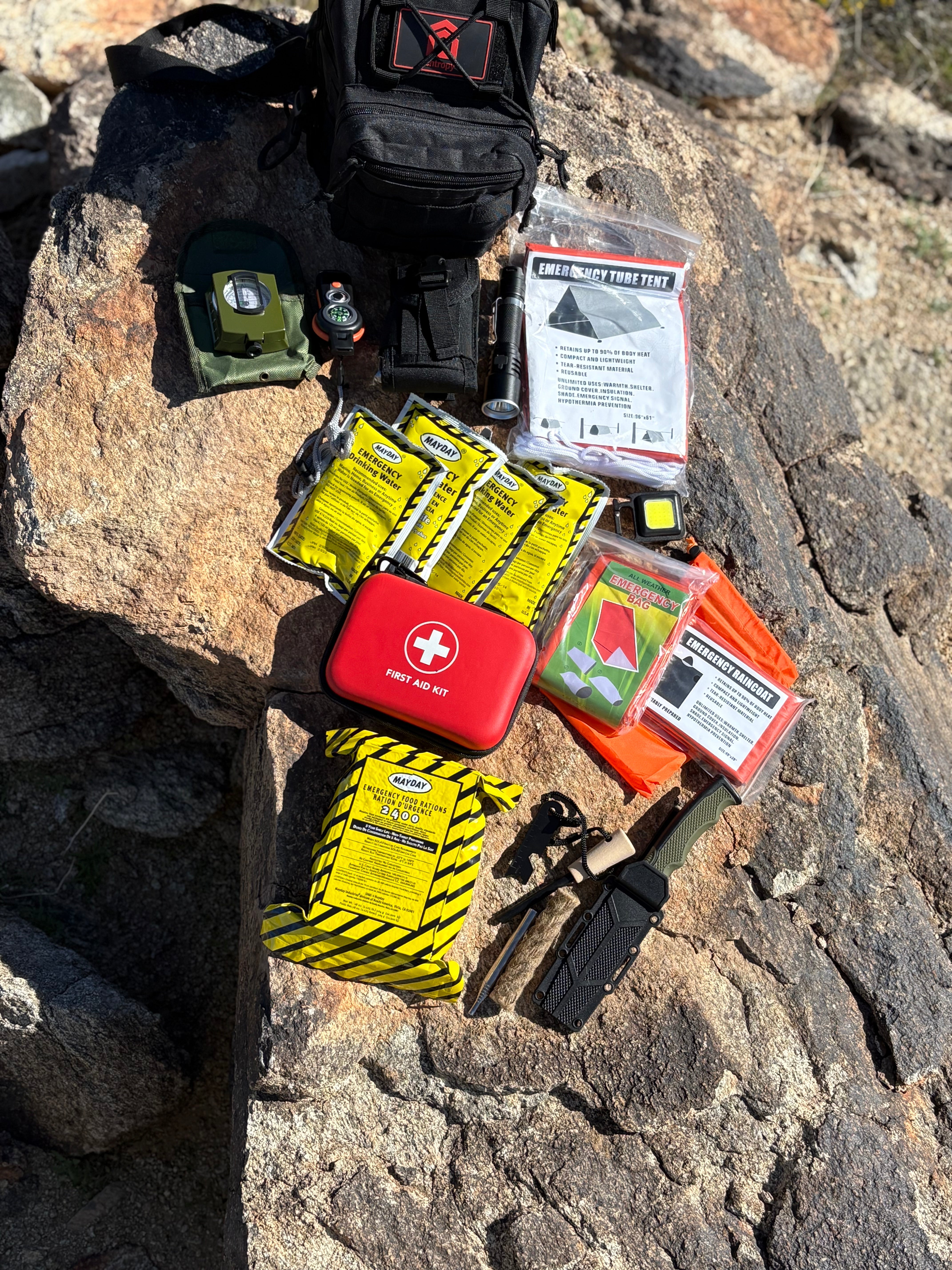 First aid kit and emergency supplies on a rocky surface