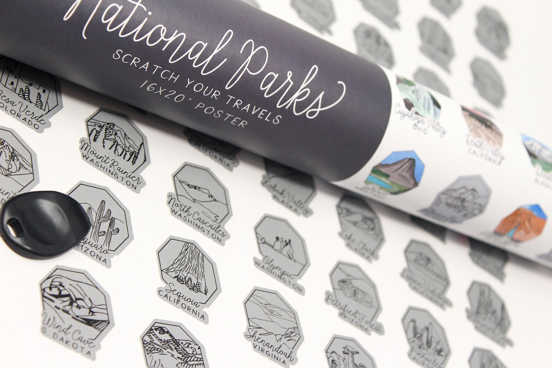 Roll of 'National Parks' scratch-off poster with black and white designs on a textured surface.