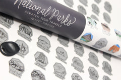 Roll of 'National Parks' scratch-off poster with black and white designs on a textured surface.
