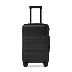 Black suitcase with wheels and handle on a white background