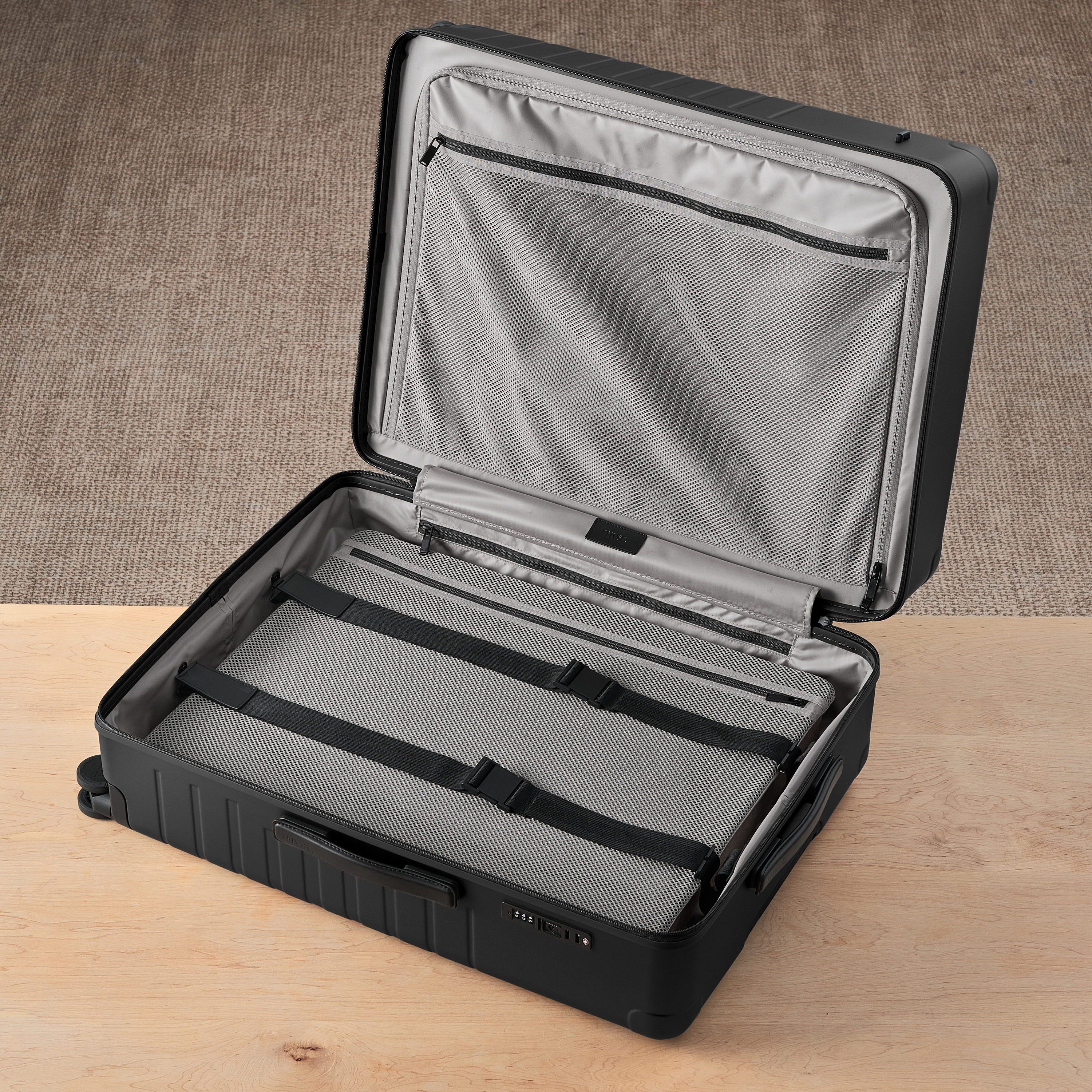 Black suitcase with open lid on a wooden surface