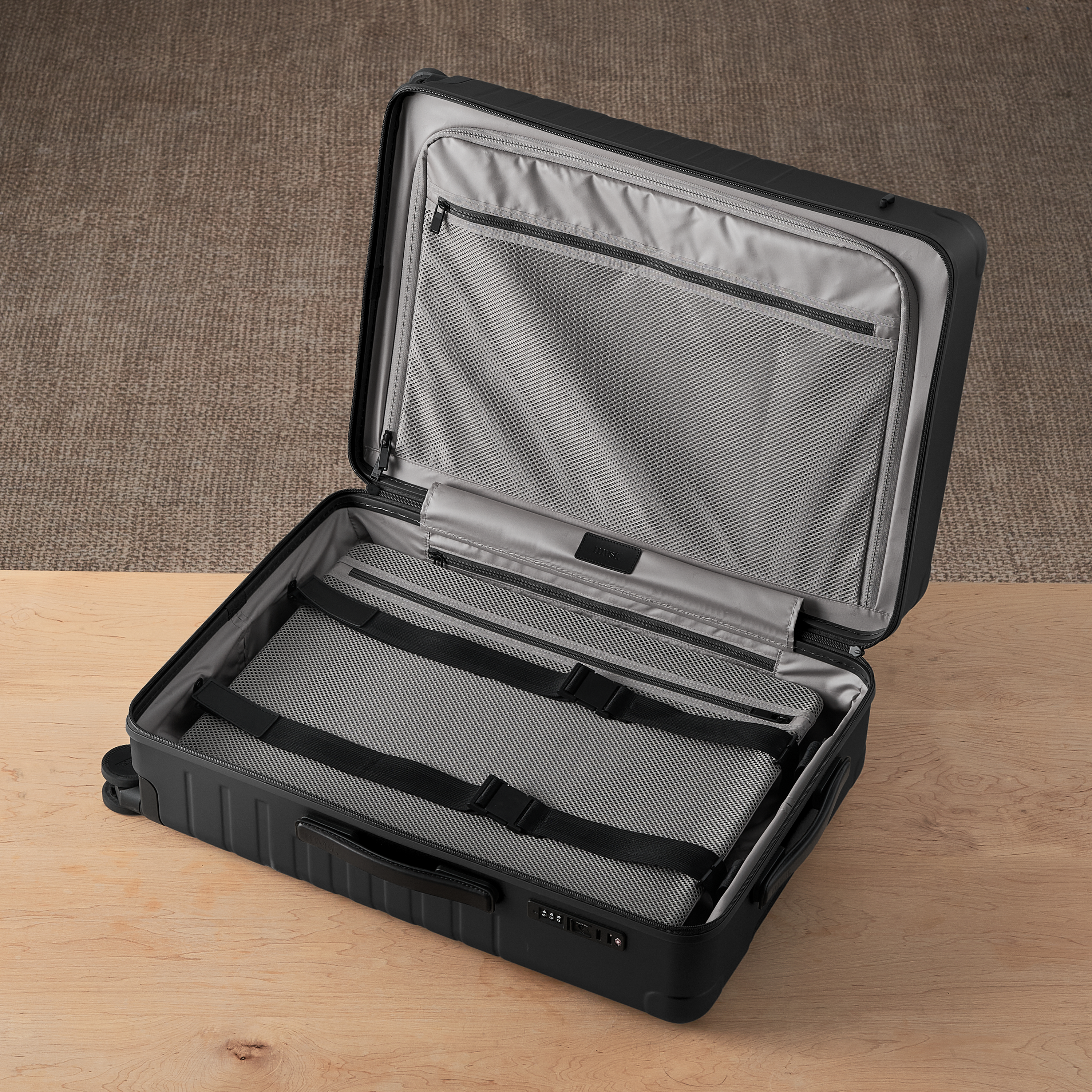 Black suitcase with open lid on a wooden surface