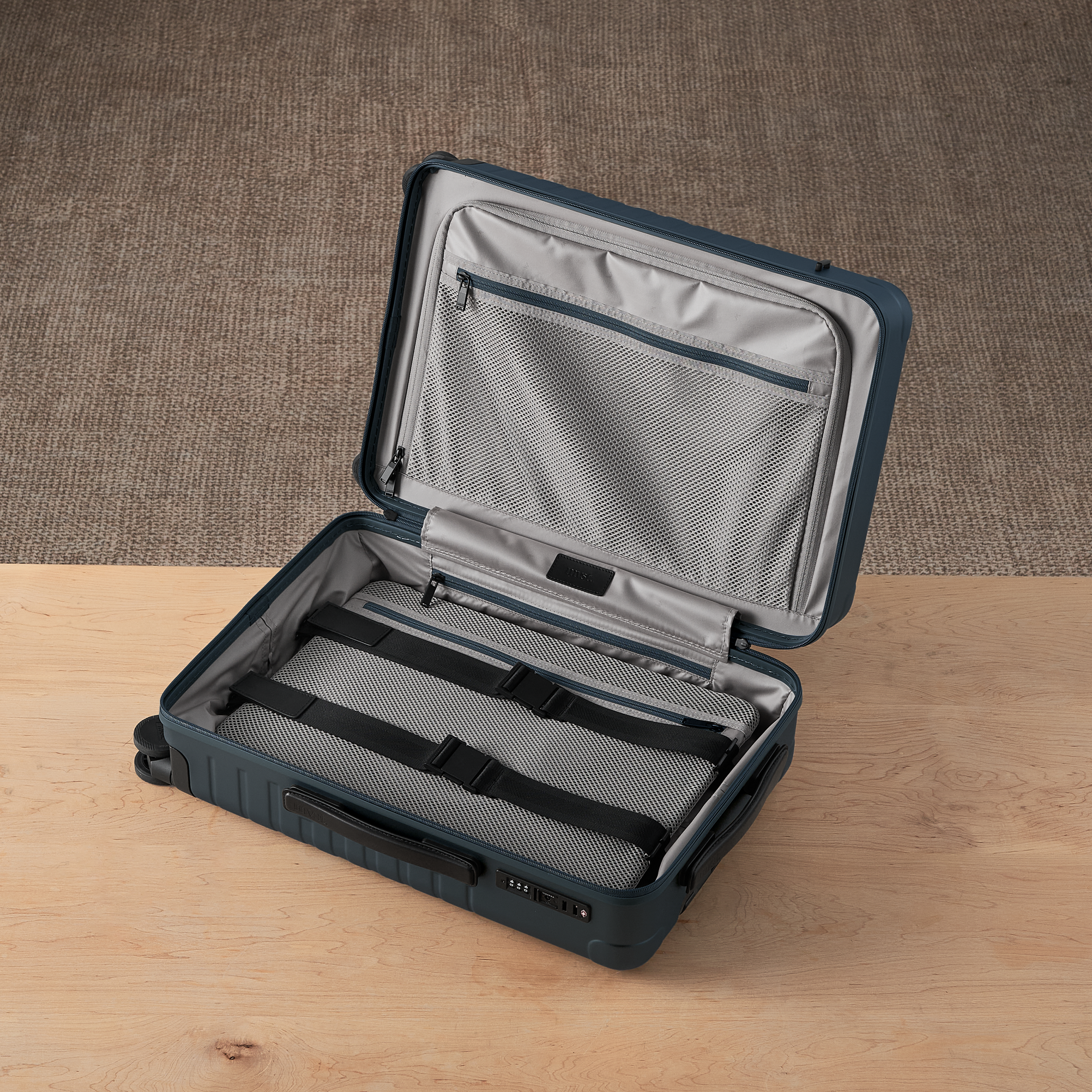 Open suitcase with gray interior on a wooden surface