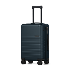 Blue suitcase with wheels and handle on a white background