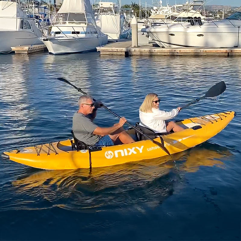 Two people in a yellow kayak with 'Nixy' branding on a marina background.