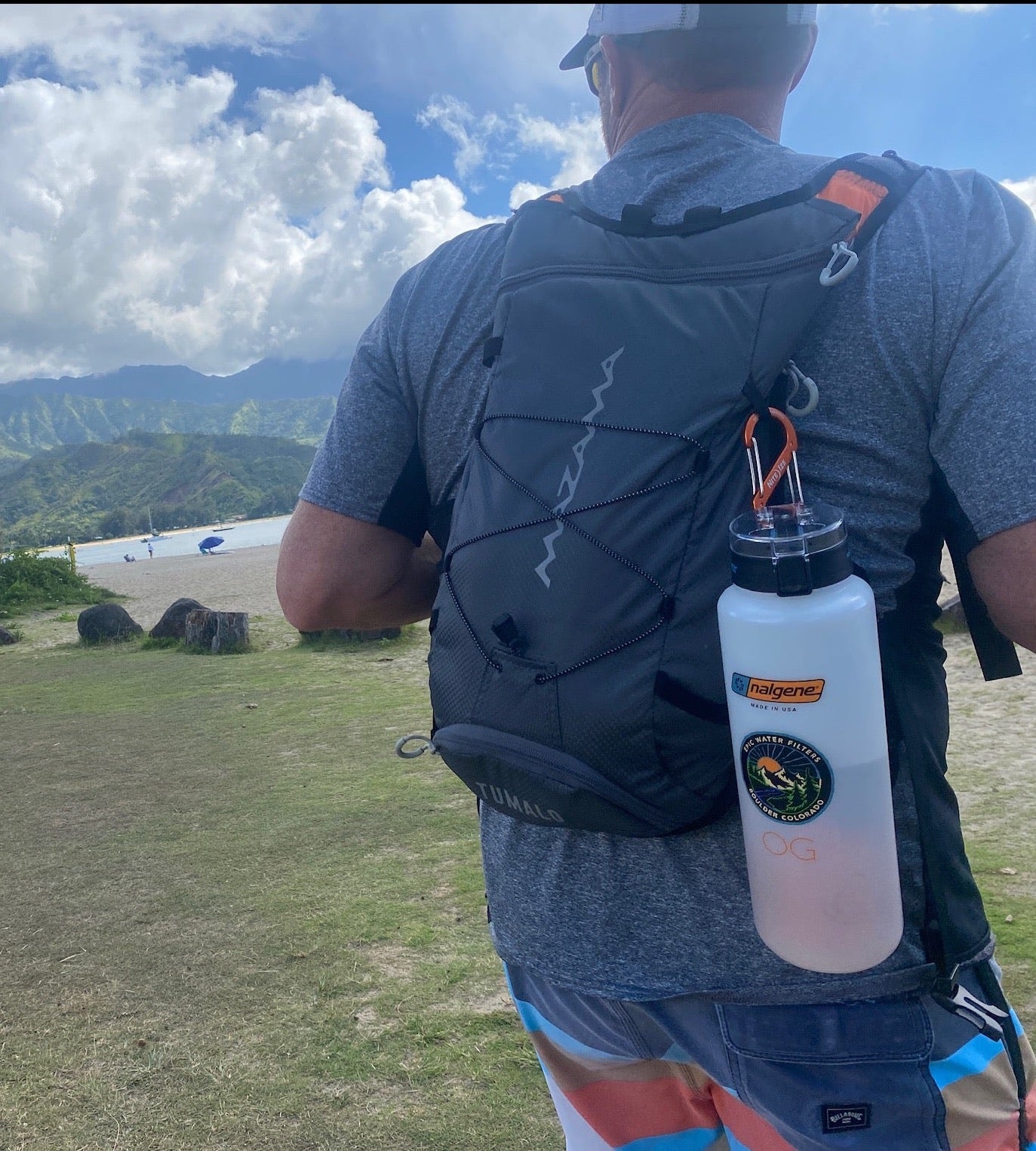 Person with a backpack and water bottle in a scenic outdoor setting