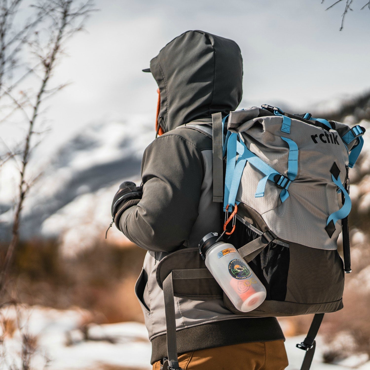 Person wearing a backpack with a visible brand logo in a snowy landscape