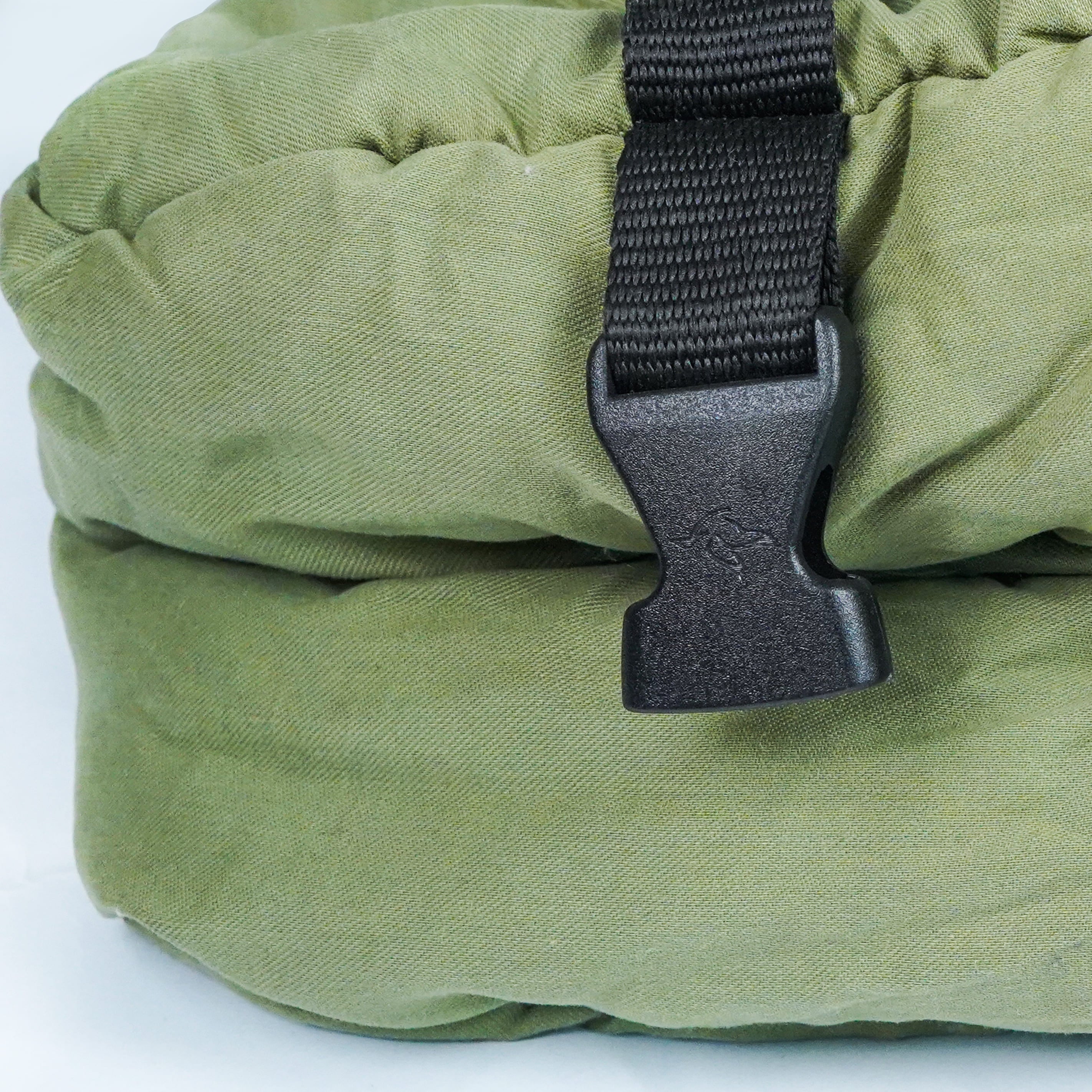 Green sleeping bag with a black buckle on a white background