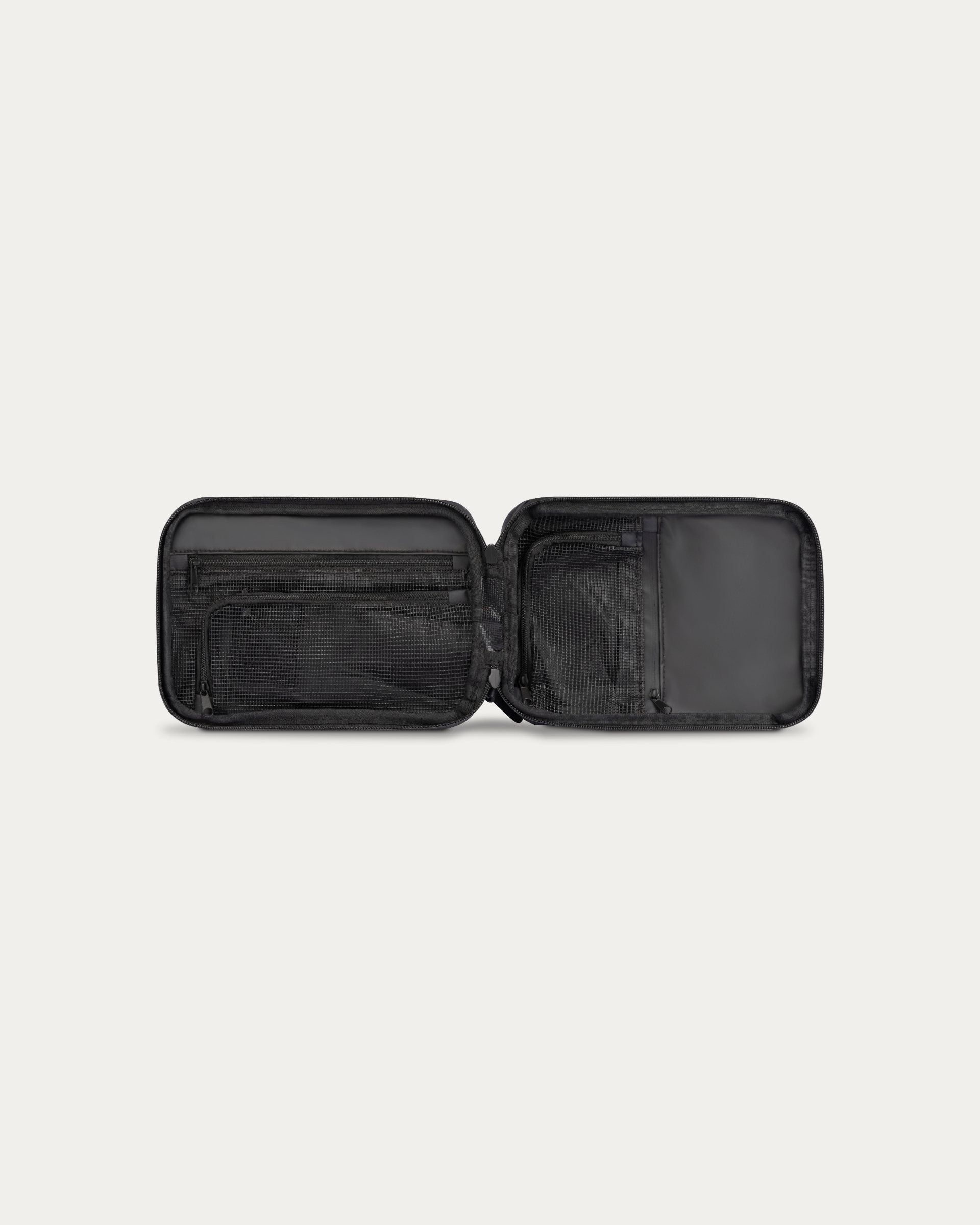 Black travel organizer with open compartments on a white background