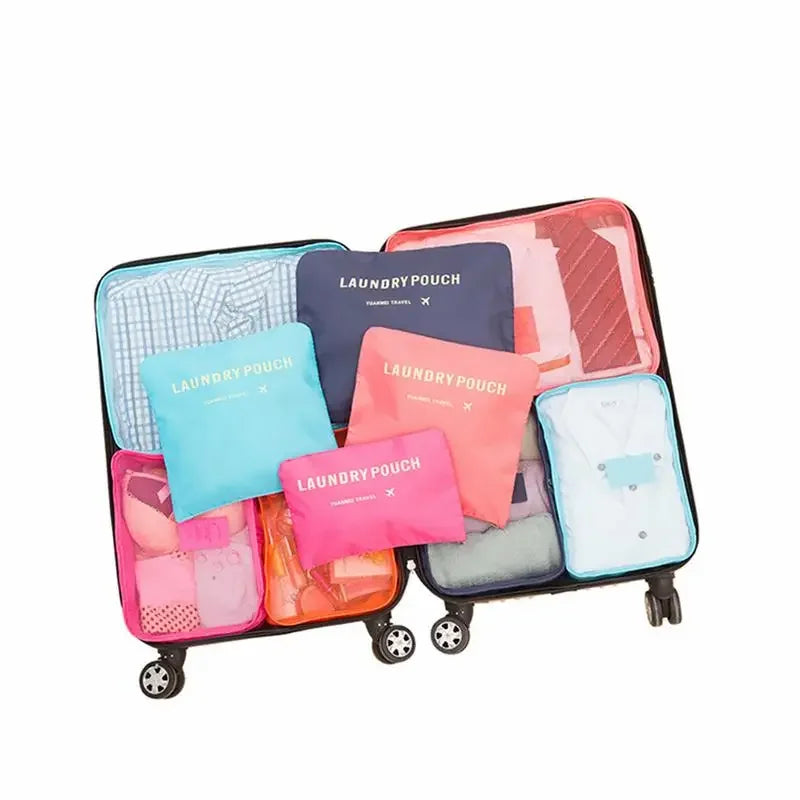Set of colorful laundry pouches inside an open suitcase on a white background
