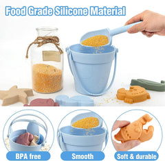 Silicone sand toys including a bucket, molds, and a jar with sand, labeled as food-grade and BPA-free.