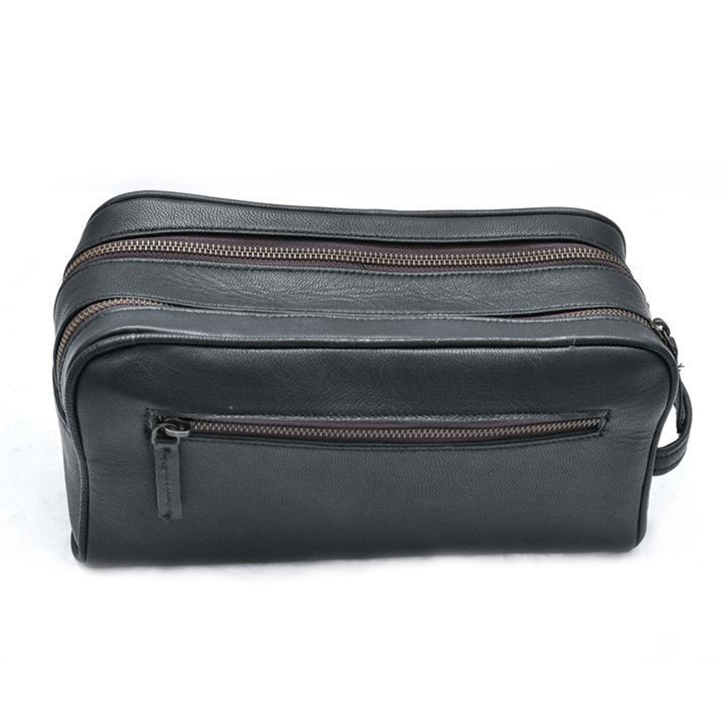 Black leather toiletry bag with multiple zippers on a white background
