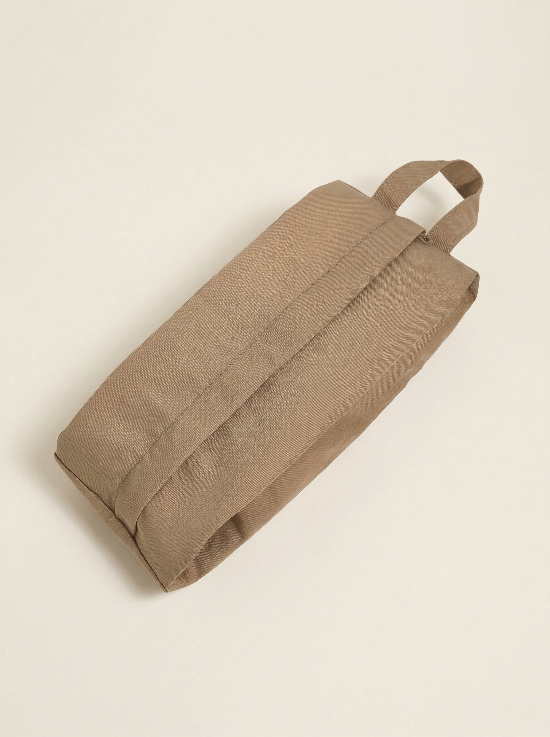 Beige bag with handles on a beige background