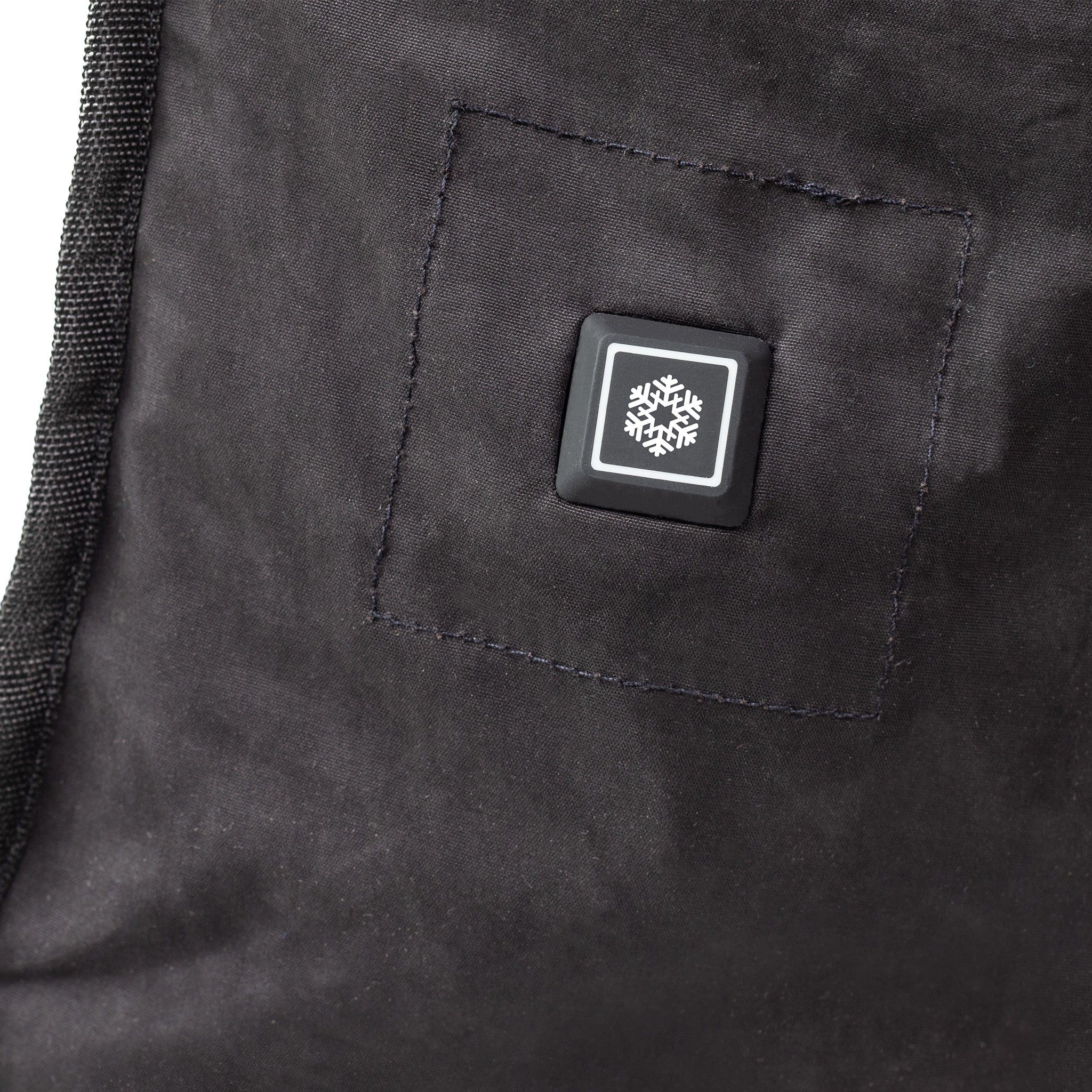 Close-up of a black textured fabric with a snowflake logo tag.