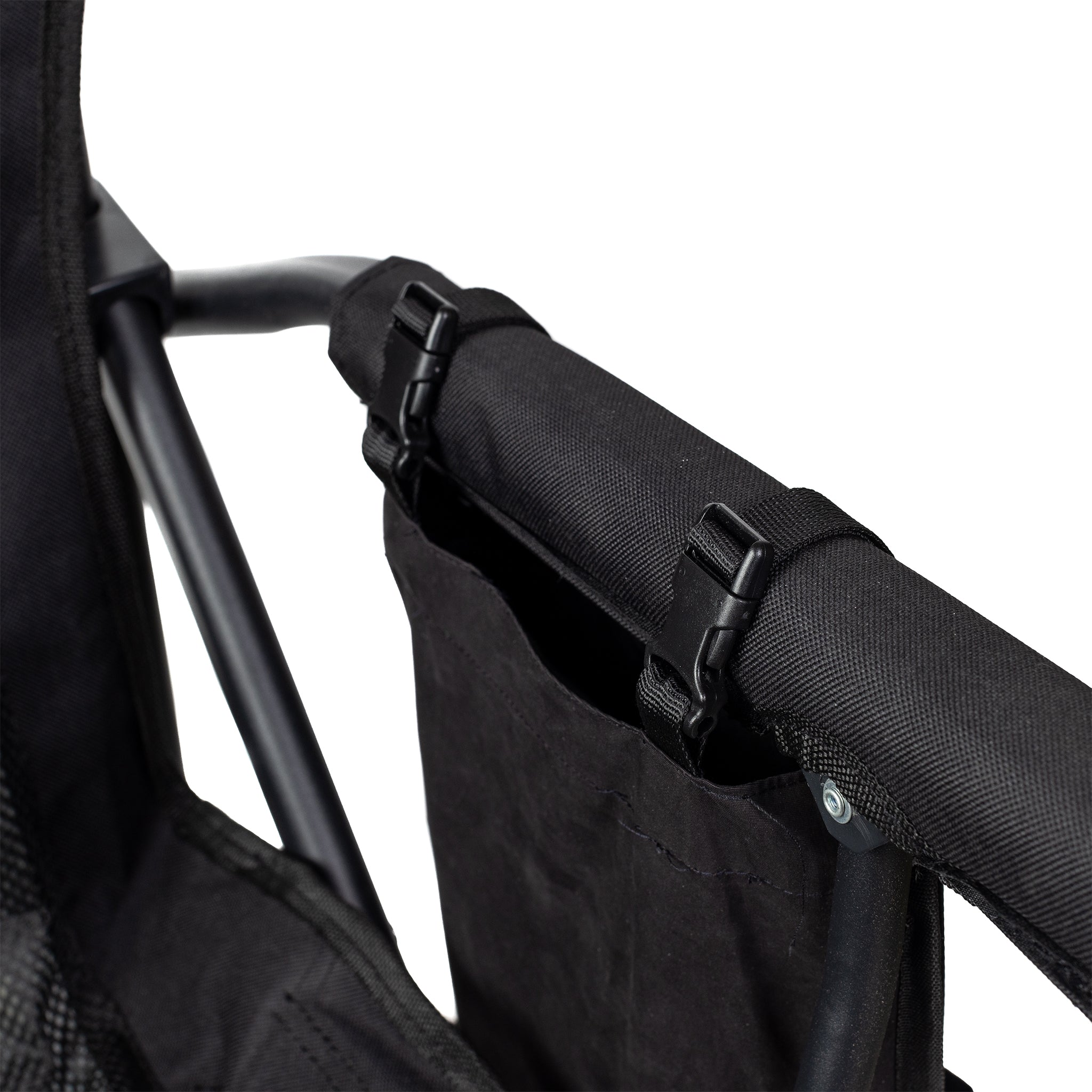 Close-up of a black stroller handle with straps on a white background