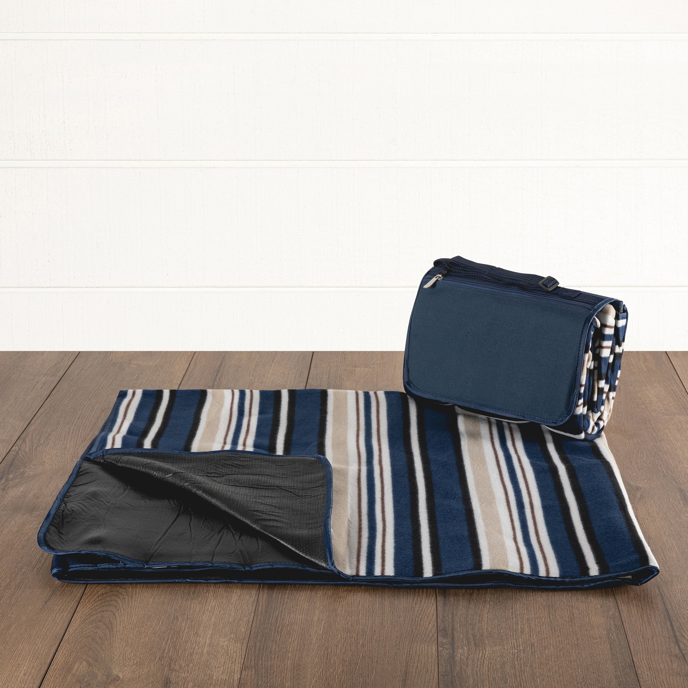 Striped picnic blanket with a matching bag on a wooden floor