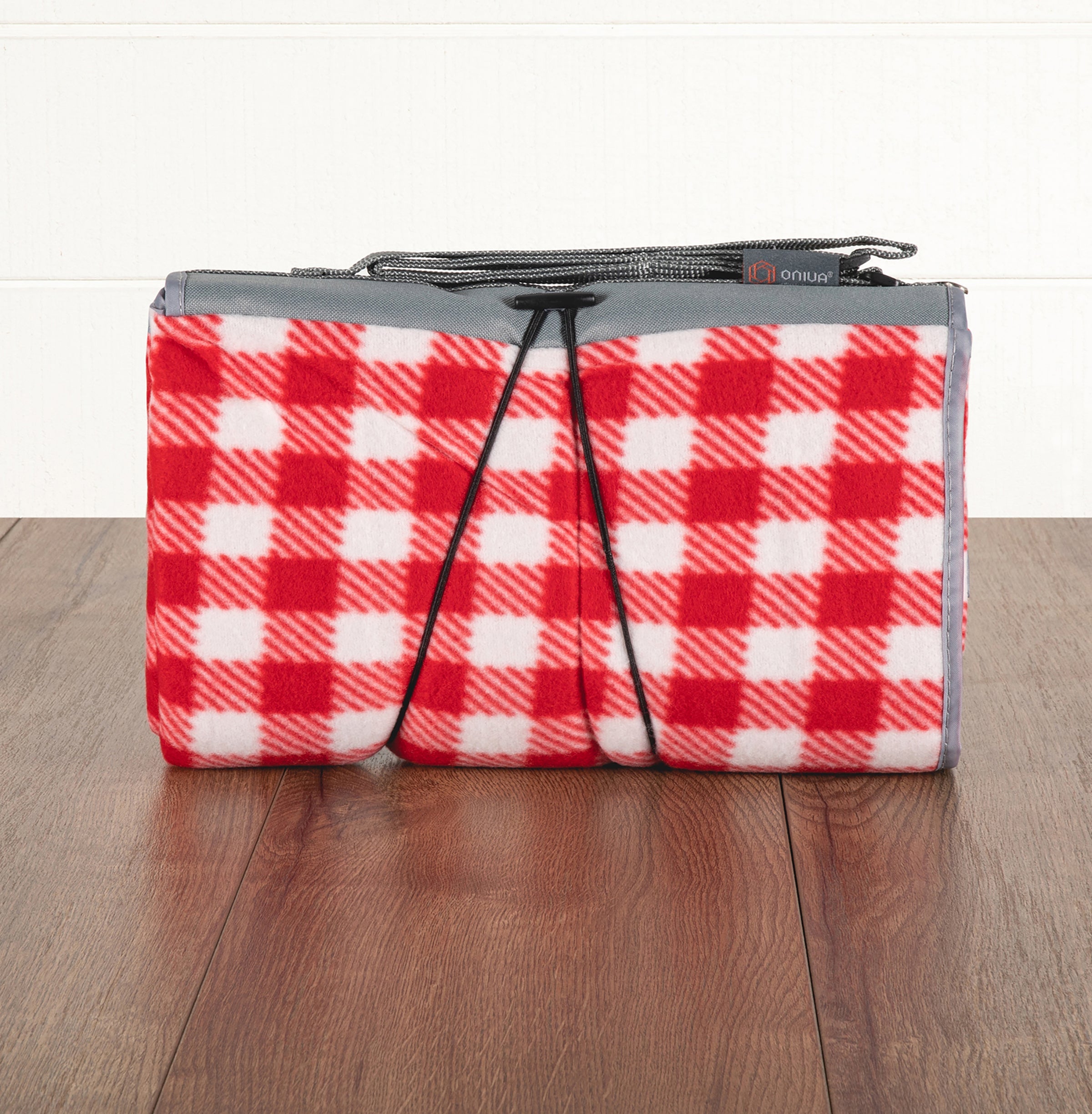 Red and white checkered bag with gray top on a wooden floor