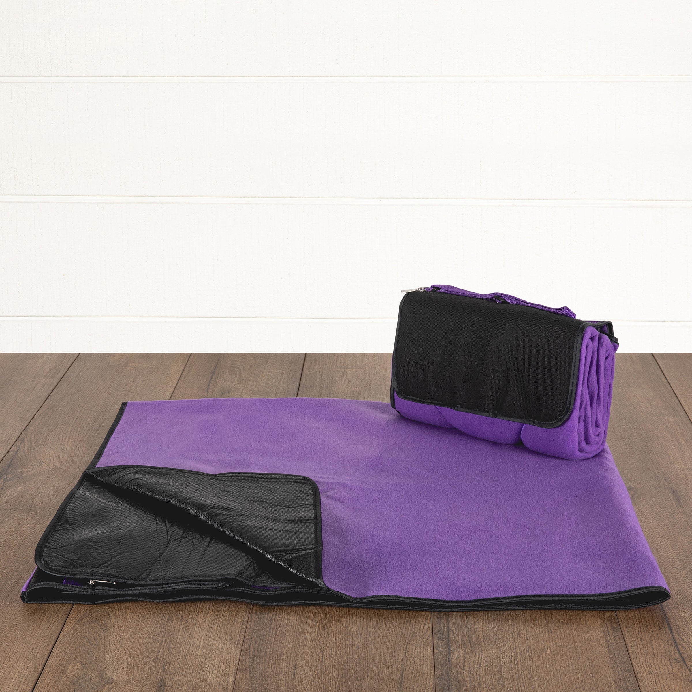 Purple and black folding blanket on a wooden floor
