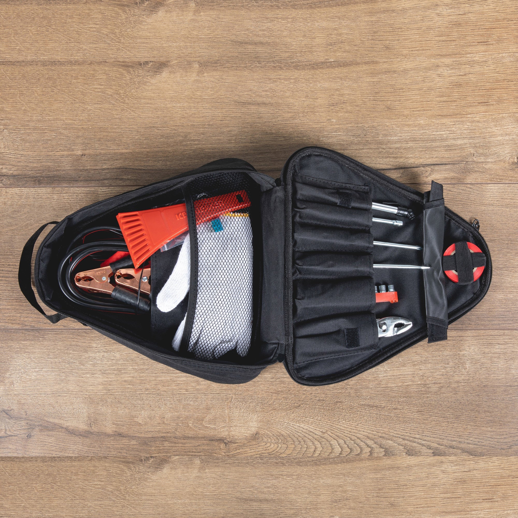 Open tool bag with tools and equipment on a wooden surface