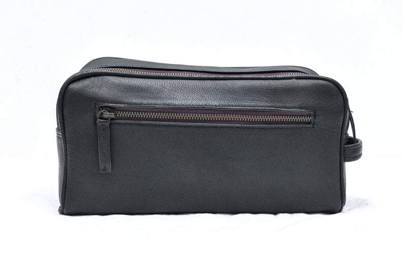Black leather toiletry bag with zipper on a white background