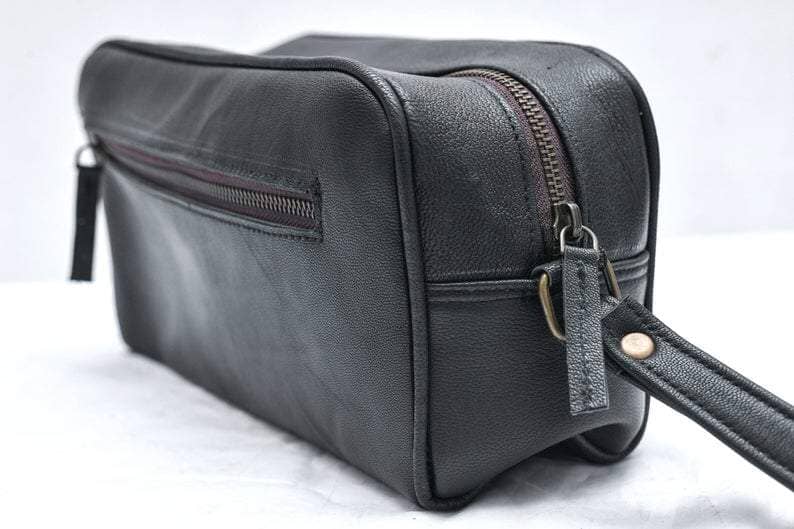 Black leather bag with a strap on a white background