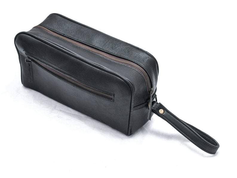 Black leather toiletry bag with a handle on a white background