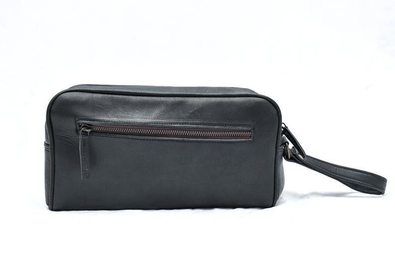 Black leather toiletry bag with zipper on a white background